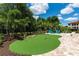 This backyard boasts a putting green, comfortable seating, and lush landscaping for outdoor enjoyment at 8180 Valhalla Ter, Reunion, FL 34747