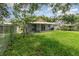 Lush backyard with green grass, mature trees, and a view of the home's covered patio at 916 Glendale St, Orlando, FL 32807