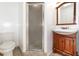 Bathroom featuring a walk-in shower, toilet, and a wood vanity with sink at 916 Glendale St, Orlando, FL 32807