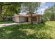 Single-story home with brick accents, bright red door, and landscaped front yard with large shady tree at 916 Glendale St, Orlando, FL 32807