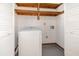Laundry area featuring a white washing machine, wooden shelves, and white louvered doors at 916 Glendale St, Orlando, FL 32807