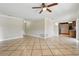 This living room features tile flooring, a ceiling fan, and a view into the kitchen at 2527 Christine Dr, Kissimmee, FL 34744