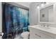 Bathroom featuring blue-themed shower curtain, grey walls, white vanity and mirror at 1007 3Rd St, Port Orange, FL 32129