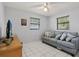 Bedroom featuring neutral walls, white tile flooring, a ceiling fan, and a comfortable gray couch at 1007 3Rd St, Port Orange, FL 32129