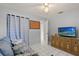 Bedroom featuring neutral walls, white tile flooring, a ceiling fan, and a comfortable gray couch at 1007 3Rd St, Port Orange, FL 32129