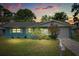 Inviting single-story home featuring a well-manicured lawn and colorful landscaping at dusk at 1007 3Rd St, Port Orange, FL 32129