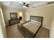 Well-lit main bedroom featuring a large bed frame, and tray ceiling with a ceiling fan at 10631 Village Lake Rd, Windermere, FL 34786