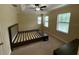 Neutral bedroom featuring a tray ceiling, ceiling fan and natural light from two windows at 10631 Village Lake Rd, Windermere, FL 34786