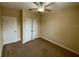 Bedroom features carpet, ceiling fan, storage closet, and neutral paint at 10631 Village Lake Rd, Windermere, FL 34786