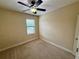 Bedroom with carpet, ceiling fan, neutral paint, and large window for natural light at 10631 Village Lake Rd, Windermere, FL 34786