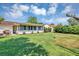 Expansive backyard featuring a lush lawn, mature landscaping, and a covered patio area perfect for outdoor dining at 10856 William Tell Dr, Orlando, FL 32821