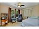 Cozy bedroom featuring a ceiling fan, comfortable armchair, and natural light streaming through the windows at 10856 William Tell Dr, Orlando, FL 32821