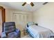 Bright bedroom with a ceiling fan, comfortable recliner, and closet for plenty of storage at 10856 William Tell Dr, Orlando, FL 32821