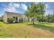 Landscaped front yard of a lovely home with vibrant flowers, healthy green grass, and mature shade trees at 10856 William Tell Dr, Orlando, FL 32821