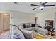 Inviting living room features comfortable seating, a ceiling fan and a mounted television at 10856 William Tell Dr, Orlando, FL 32821