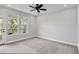 Sunlit bedroom with neutral tones, a ceiling fan, and a door leading to a private balcony at 117 E Concord St # 7, Orlando, FL 32801