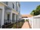 Side exterior view of the townhome showing fence, lawn and pathway at 117 E Concord St # 7, Orlando, FL 32801