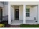 View of the covered front porch with a black front door and green lawn at 117 E Concord St # 7, Orlando, FL 32801