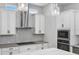 Bright kitchen featuring white cabinetry, stainless steel appliances, quartz countertops, and an elegant mosaic tile backsplash at 117 E Concord St # 7, Orlando, FL 32801