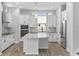 Modern kitchen with white cabinetry, stainless steel appliances, a center island with quartz countertop, and elegant pendant lighting at 117 E Concord St # 7, Orlando, FL 32801