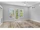 Bright living room with neutral walls, wood floors, and access to a balcony offering views of city buildings and lush trees at 117 E Concord St # 7, Orlando, FL 32801