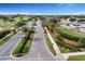 Aerial view of gated community entrance with palm trees, landscaping, and golf course at 125 Owenshire Cir, Kissimmee, FL 34744