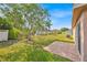 Spacious backyard featuring a brick patio, mature tree, and partial privacy fence, perfect for outdoor enjoyment at 125 Owenshire Cir, Kissimmee, FL 34744