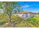 Wide backyard featuring mature trees, a sliding glass door, and a brick patio, enhancing outdoor living at 125 Owenshire Cir, Kissimmee, FL 34744