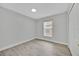 Neutral bedroom featuring wood laminate flooring and a large window at 125 Owenshire Cir, Kissimmee, FL 34744