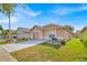 Charming single-story home with attached garage, well-maintained lawn, and blue sky at 125 Owenshire Cir, Kissimmee, FL 34744