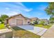 A view of a well-maintained single-story home with a spacious driveway and manicured lawn on a sunny day at 125 Owenshire Cir, Kissimmee, FL 34744