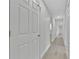 Clean, bright hallway with white doors, light wood floors, and neutral paint for a modern look at 125 Owenshire Cir, Kissimmee, FL 34744