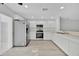 White kitchen featuring white cabinets, stainless steel appliances, and laminate flooring at 125 Owenshire Cir, Kissimmee, FL 34744
