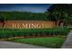 Brick sign for 'Remington' with manicured hedges and colorful flowerbeds at 125 Owenshire Cir, Kissimmee, FL 34744