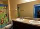 Bathroom featuring dual sinks, granite counters, decorative shower curtain, and a toilet at 12610 Sawgrass Oak St, Orlando, FL 32824