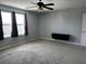 Large bedroom with neutral carpet, two windows, and a ceiling fan at 12610 Sawgrass Oak St, Orlando, FL 32824