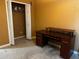 Bedroom with neutral carpet, a dark wood desk, and a closet with double doors at 12610 Sawgrass Oak St, Orlando, FL 32824