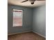 A cozy bedroom is painted light blue and features a window with bamboo blinds and a ceiling fan at 12610 Sawgrass Oak St, Orlando, FL 32824