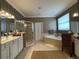 Bathroom with double vanity, glass shower, tub, and tiled floors and decorative wall paper at 13016 Islamorada Dr, Orlando, FL 32837