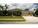 Charming single-story home with a three car garage, manicured lawn, and lush landscaping at 13016 Islamorada Dr, Orlando, FL 32837