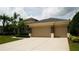 Three car garage with stone accents and a well maintained driveway with ample parking space at 13016 Islamorada Dr, Orlando, FL 32837