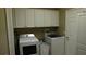 A functional laundry room with white cabinets, washer, and dryer for convenient chores at 13016 Islamorada Dr, Orlando, FL 32837