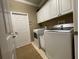A functional laundry room with white washer and dryer, cabinets, and ample space for laundry tasks at 13016 Islamorada Dr, Orlando, FL 32837