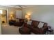 Spacious living room featuring neutral colored walls, carpet and leather sofa at 13016 Islamorada Dr, Orlando, FL 32837
