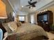 Comfortable main bedroom featuring tray ceilings, ceiling fan, and built in tv console at 13016 Islamorada Dr, Orlando, FL 32837