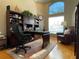 Home office with hardwood floors, a large window, a bookcase, and comfortable furniture at 13016 Islamorada Dr, Orlando, FL 32837