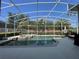 Screened-in pool and spa with mature landscaping and privacy wall at 13016 Islamorada Dr, Orlando, FL 32837