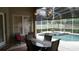 Outdoor pool area with a covered patio, dining set, and lush landscaping at 13016 Islamorada Dr, Orlando, FL 32837
