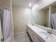 Bathroom featuring double sinks, a large mirror, tiled floor, and a shower with curtain at 1308 Shinnecock Hills Dr, Davenport, FL 33896