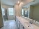 Bathroom featuring double sinks, a large mirror, tiled floor, and a glass-enclosed shower at 1308 Shinnecock Hills Dr, Davenport, FL 33896